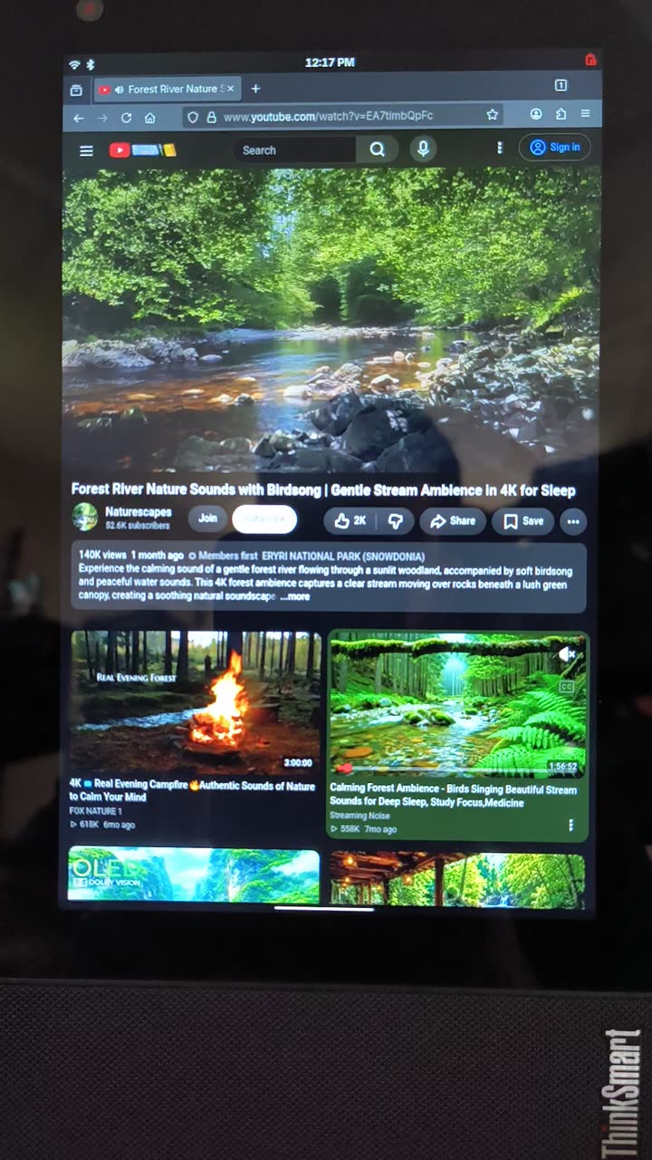 The ThinkSmart View on a desk, running Firefox on postmarketOS with a YouTube video playing — the ThinkSmart logo still on the bezel